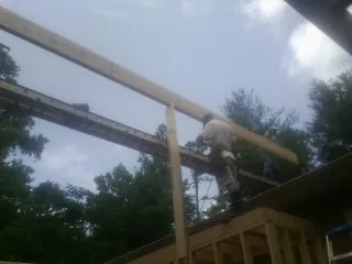 Carpenter setting a ridge beam over a new addition frame — Ice Dam Removal by Roofing Brothers in Millersburg