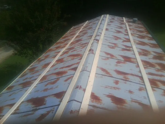 Rusted metal roof panels with new wood purlins before replacement — Storm Damage Roof Repair in Millersburg by Roofing Brothers
